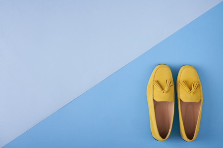 Yellow woman's moccasins shoes over blue background, top viewの写真素材
