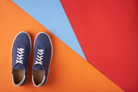 Couple of casual unisex suede sneakers standing on multicolored background, flat lay styleの写真素材