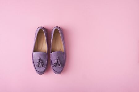 Lilac suede moccasins shoes over lilac pink background, top viewの写真素材