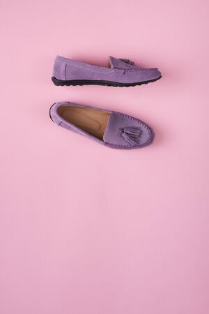 Lilac suede moccasins shoes over lilac pink background, top viewの写真素材