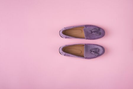 Lilac suede moccasins shoes over lilac pink background, top viewの写真素材