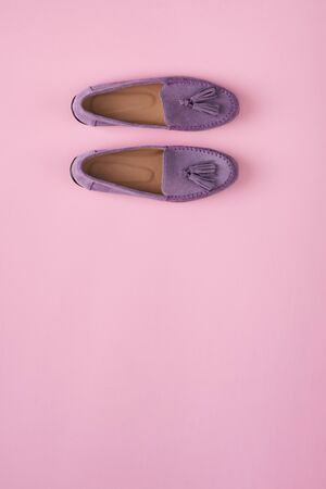Lilac suede moccasins shoes over lilac pink background, top viewの写真素材