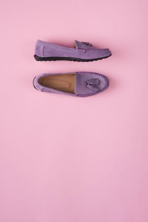 Lilac suede moccasins shoes over lilac pink background, top viewの写真素材