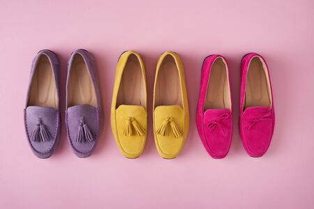 Multicolored suede moccasins shoes standing in line over pink background, top viewの写真素材