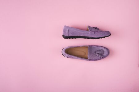 Lilac suede moccasins shoes over lilac pink background, top viewの写真素材