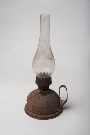 Old rusty and dirty antique kerosene oil lantern brass lamp isolated on whiteの写真素材