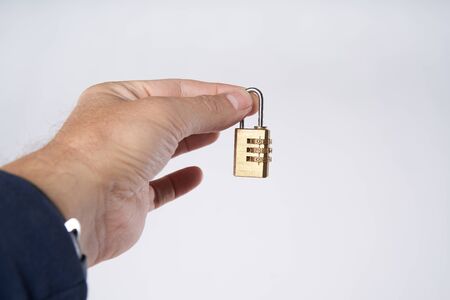 Man's hand holding small combination lockの写真素材