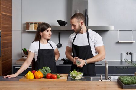 Young family in the kitchen with vegetables preparing saladの写真素材