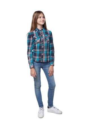 Full length teen girl in checkered shirt standing casually over white background looking to sideの写真素材