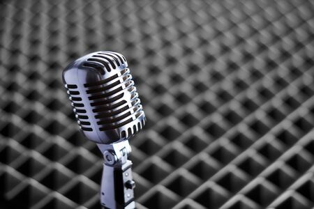 Closeup of chrome retro condenser microphone on acoustic foam panel backgroundの写真素材