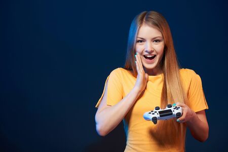 Gamer girl. Excited happy woman with video game joystick sceaming of joyの写真素材