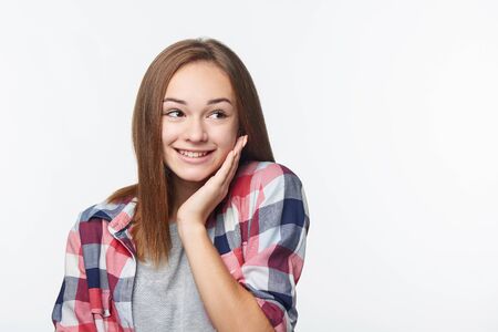 Surprised teen girl looking to side at blank copy space, studio portraitの写真素材