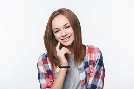 Smiling relaxed teen girl looking at camera, studio portraitの写真素材