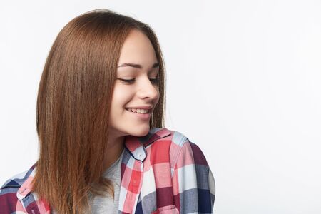 Smiling relaxed teen girl looking to side playful, studio portraitの写真素材
