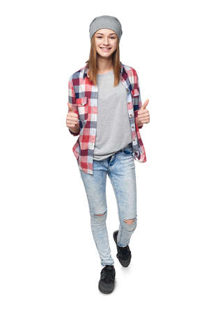 Smiling teen girl in full length looking at camera giving double thumb up, isolated on whiteの写真素材