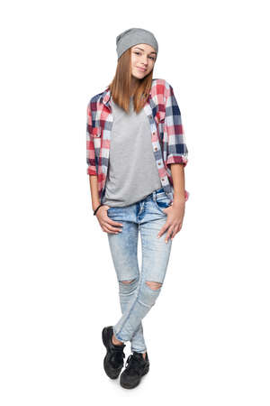 Smiling relaxed teen girl standing in full length, looking at camera, studio portraitの写真素材