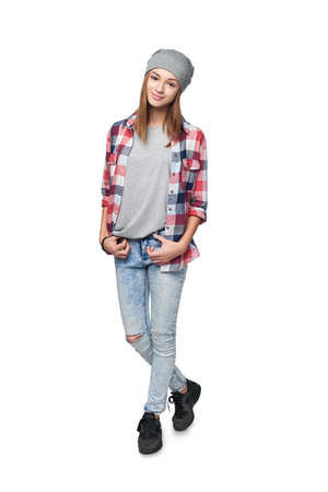 Smiling relaxed teen girl standing in full length, looking at camera, studio portraitの写真素材
