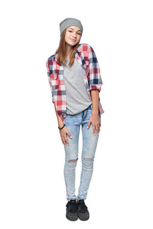 Smiling relaxed teen girl standing in full length, looking at camera, studio portraitの写真素材