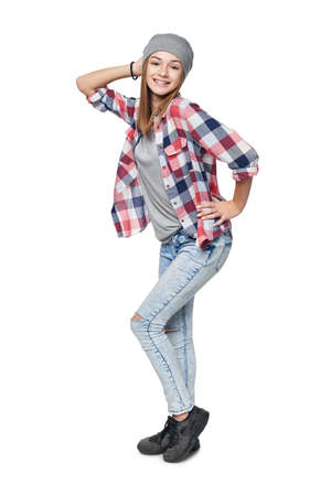 Smiling teen girl standing in full length posing, looking at camera, studio portraitの写真素材