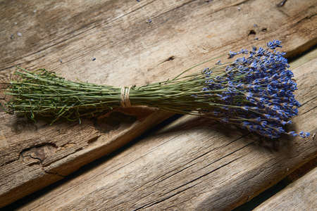 A bunch of lavender flowers on rough wooden planksの写真素材