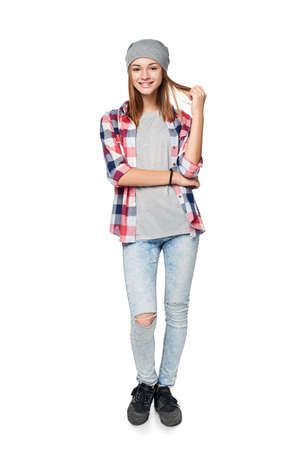 Smiling relaxed teen girl standing in full length, looking at camera, studio portraitの写真素材