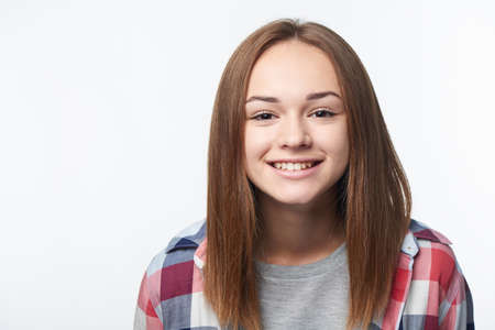 Closeup of happy smiling teen girl looking at camera, studio portraitの写真素材