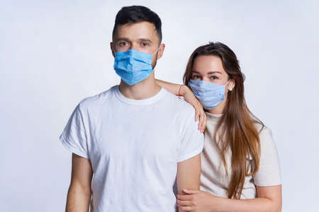 Young couple wearing medicine masks standing looking at cameraの写真素材