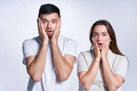 Human emotions and feelings. Shocked young couple or family screaming, looking at camera in full...