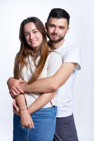 Attractive young couple hugging looking at camera smilingの写真素材