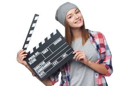 Happy smiling teen girl holding clap board, over white backgroundの写真素材