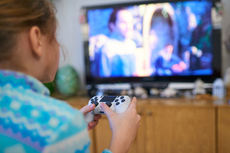 Girl playing video game with joystick at homeの写真素材