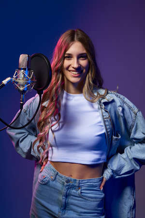 Girl blogger recording audio podcast. Happy smiling girl with microphoneの写真素材