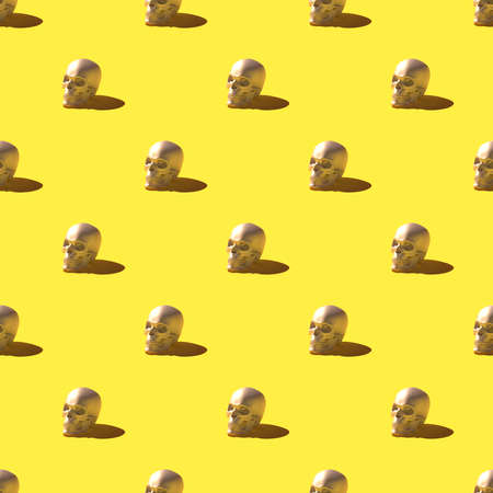 Seamless pattern of 3D render skulls over bright yellow backgroundの写真素材