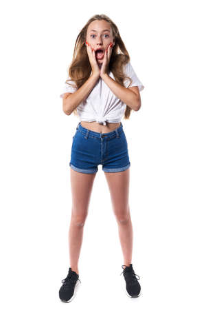 Full length of shocked teen standing over white background shouting looking at cameraの写真素材
