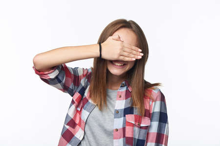 Emotional joyful girl covering her eyes with palmの写真素材