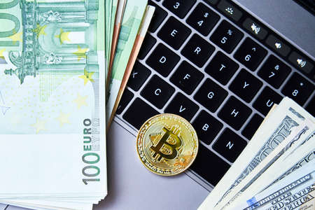 Golden bitcoin coin on laptop keyboardの写真素材