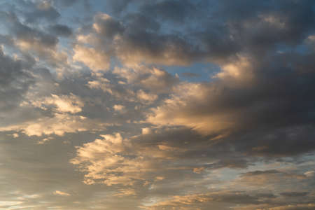 Dramatic cloudscape on sunset with glowing golden cumulus cloudsの写真素材