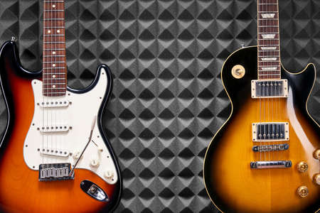 Two electric guitars on acoustic foam panel backgroundの写真素材