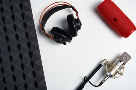 Microphone, headphones and portable stereo speaker on on white background with copy space and acoustic foam panelの写真素材