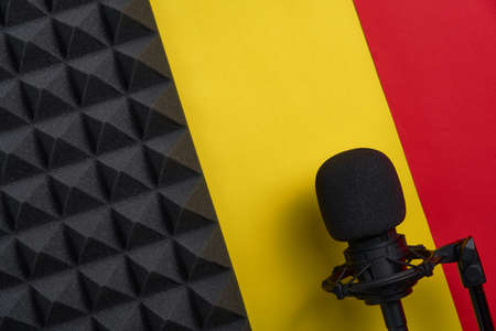 Flat lay of microphone and acoustic foam panel, over red and yellow backgroundの写真素材
