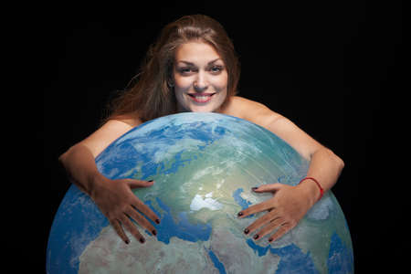 Happy beautiful woman hugging earth globeの写真素材