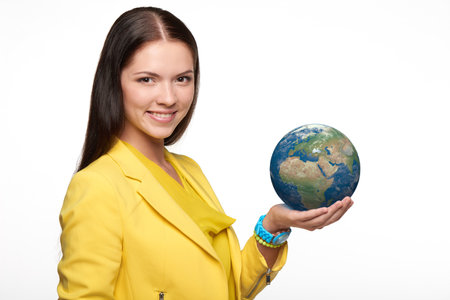 Happy smiling woman holding small earth globe on her palmの写真素材