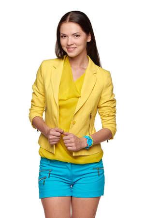 Happy smiling brunette girl wearing yellow jacket and blue shortsの写真素材