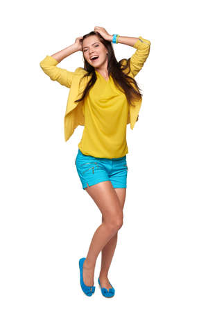 Full length of happy young girl in yellow and blue clothes screaming of joyの写真素材