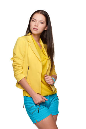 Happy smiling girl wearing yellow jacket and blue shortsの写真素材
