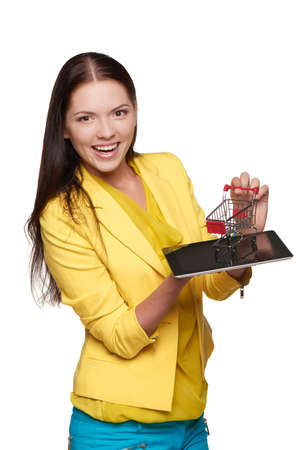 Smiling casual woman standing with small empty shopping cart basket on her palmの写真素材