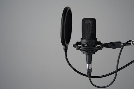 Black studio condenser microphone with pop up filter, isolated on grey backgroundの写真素材