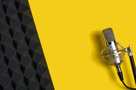 Microphone on yellow background with copy space and acoustic foam panelの写真素材