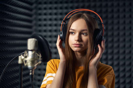 Calm girl in recording studio in headphones with micの写真素材