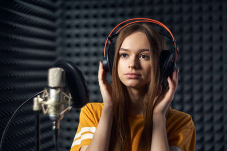 Calm girl in recording studio in headphones with micの写真素材